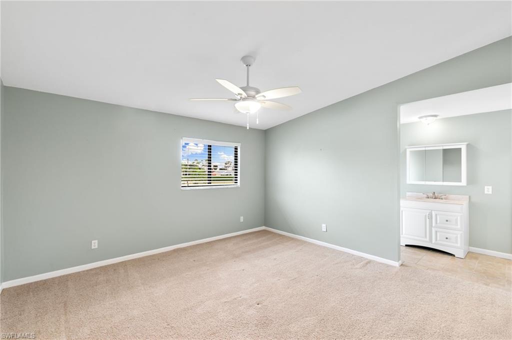17017 Golfside Circle, Unit 404 Fort Myers, FL 33908 - Photo 12 of 22 an empty room with a chandelier fan and windows