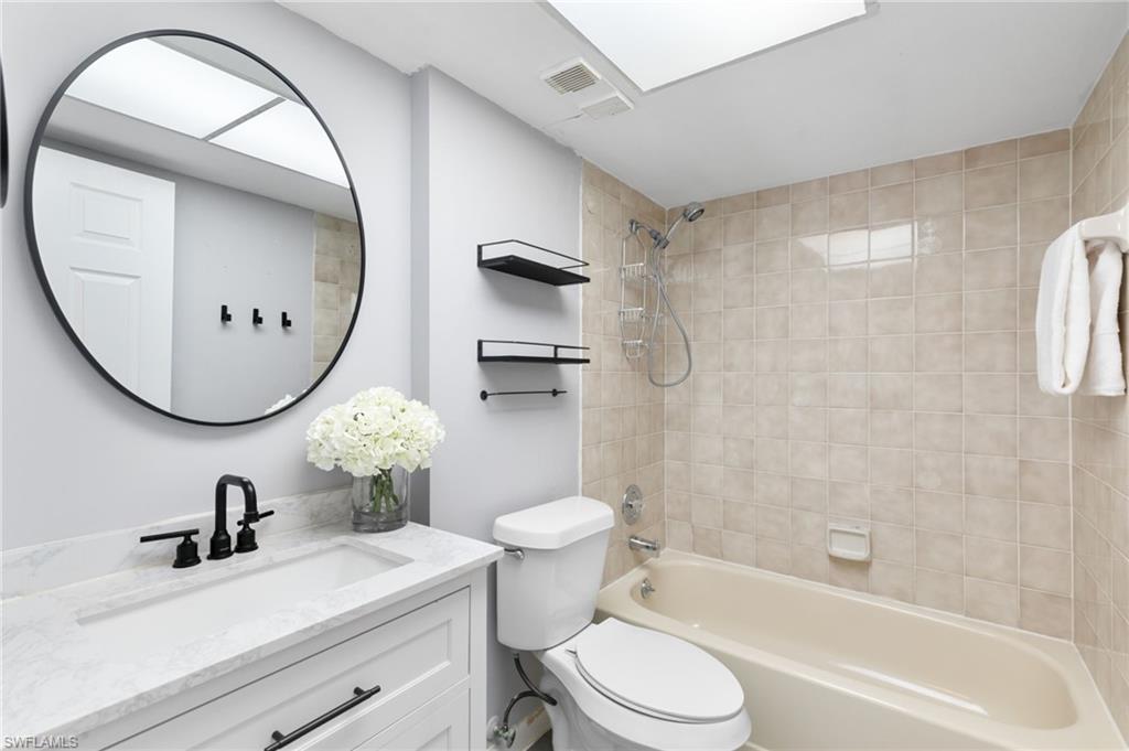 17017 Golfside Circle, Unit 404 Fort Myers, FL 33908 - Photo 15 of 22 a bathroom with a sink a toilet and a mirror