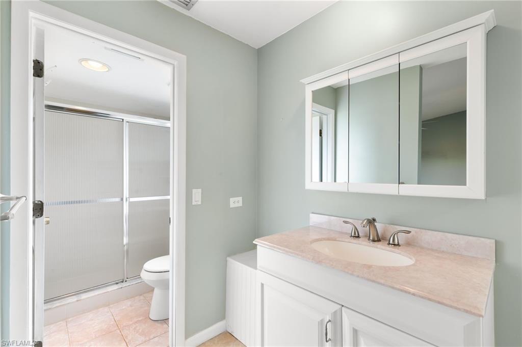 17017 Golfside Circle, Unit 404 Fort Myers, FL 33908 - Photo 16 of 22 a bathroom with a granite countertop sink toilet and shower