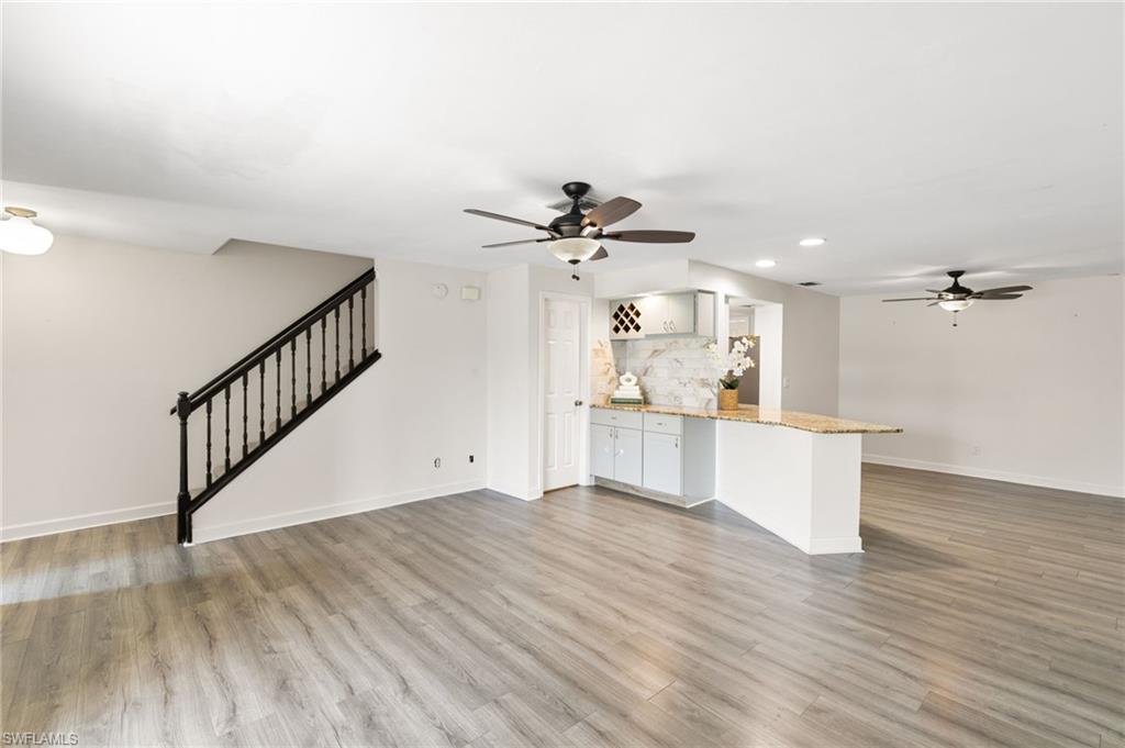17017 Golfside Circle, Unit 404 Fort Myers, FL 33908 - Photo 3 of 22 a view of a kitchen with wooden floor and a ceiling fan