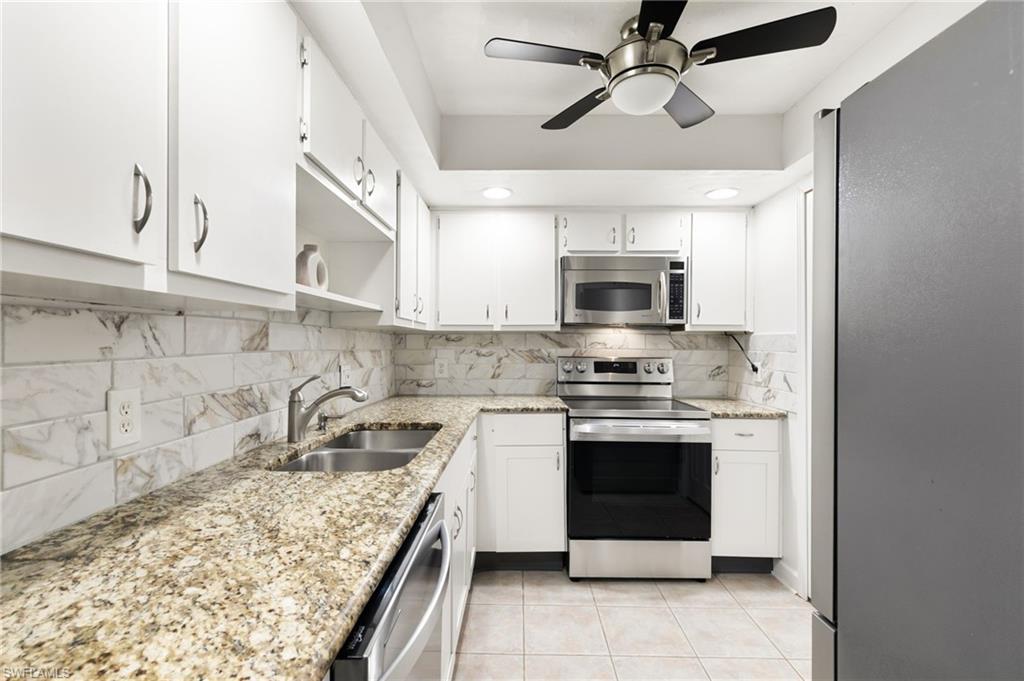 17017 Golfside Circle, Unit 404 Fort Myers, FL 33908 - Photo 8 of 22 a kitchen with stainless steel appliances granite countertop a stove and a sink
