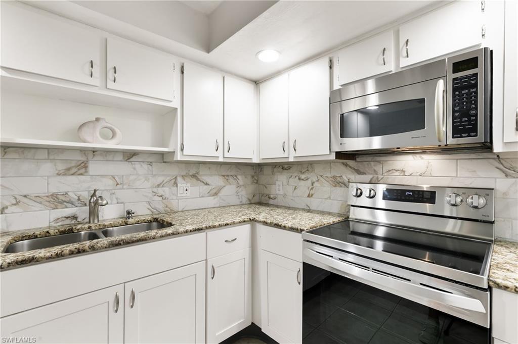 17017 Golfside Circle, Unit 404 Fort Myers, FL 33908 - Photo 9 of 22 a kitchen with stainless steel appliances granite countertop a sink and a stove top oven