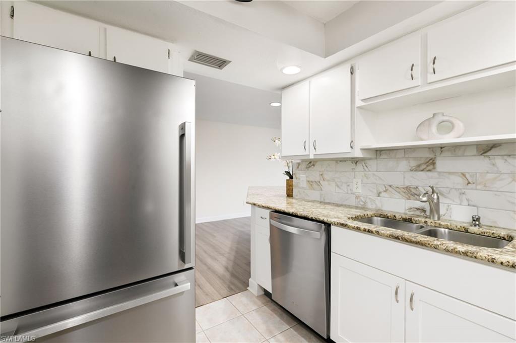 17017 Golfside Circle, Unit 404 Fort Myers, FL 33908 - Photo 10 of 22 a kitchen with stainless steel appliances granite countertop a sink and a refrigerator