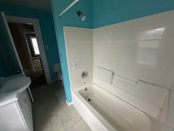 a bathroom with a tub a sink and a large mirror