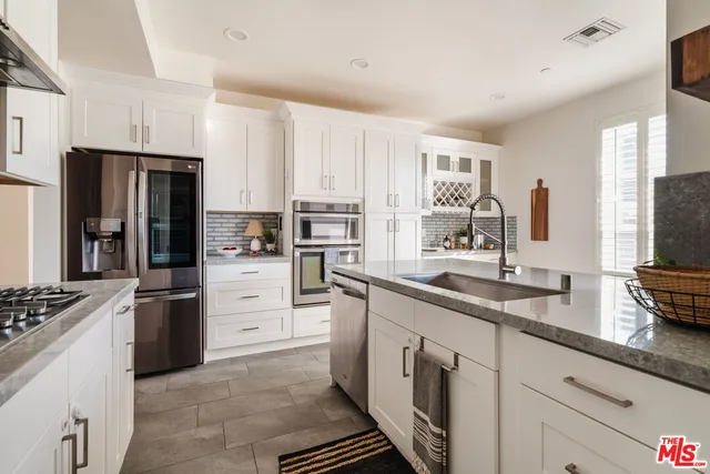 a view of kitchen with stainless steel appliances granite countertop a refrigerator and a stove