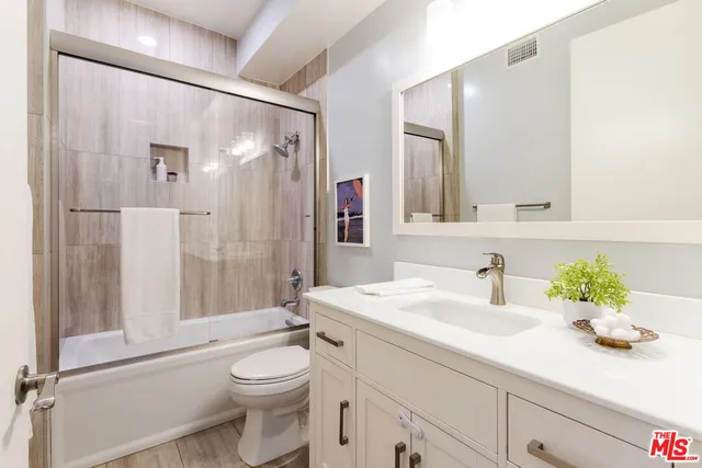 a bedroom with a bed and a potted plant