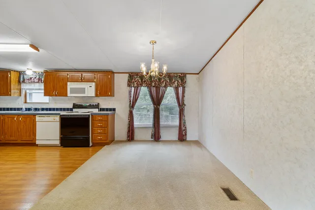 a view of kitchen with granite countertop window and stainless steel appliances
