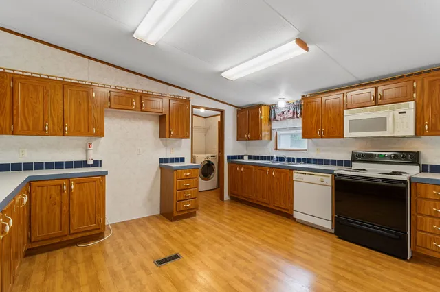 a kitchen with stainless steel appliances wooden floors and wooden cabinets