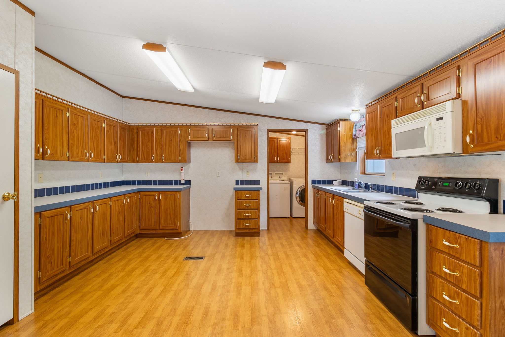 121 West Oak Shadows Onalaska, TX 77360 - Photo 7 of 20 a kitchen with stainless steel appliances wooden floors and wooden cabinets