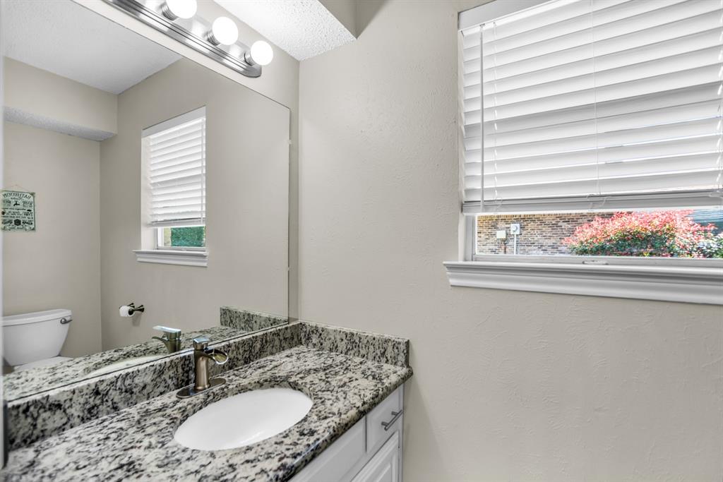 5902 Fawn Valley Lane Rowlett, TX 75089 - Photo 14 of 27 a bathroom with a granite countertop sink a large mirror and a window