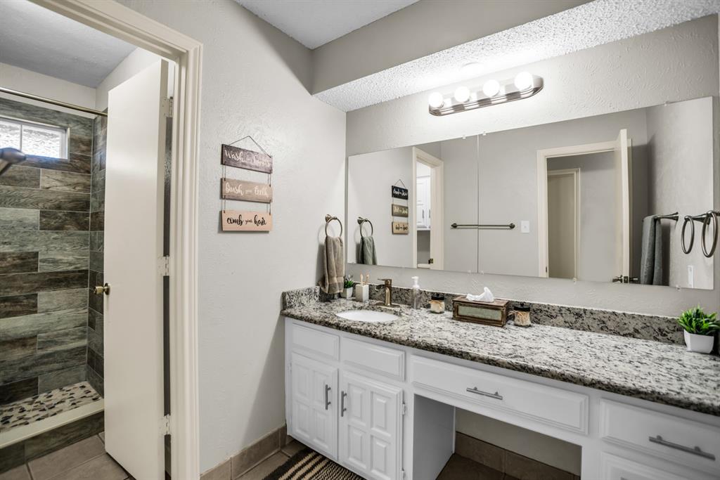 5902 Fawn Valley Lane Rowlett, TX 75089 - Photo 16 of 27 a bathroom with a granite countertop sink and a mirror