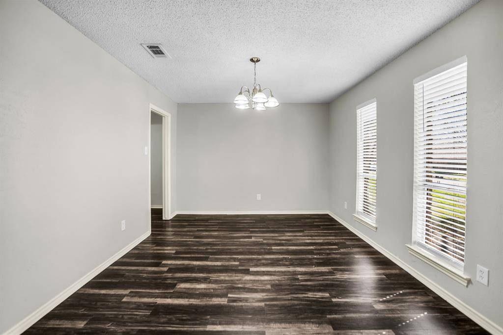 5902 Fawn Valley Lane Rowlett, TX 75089 - Photo 3 of 27 a view of an empty room with wooden floor and a window