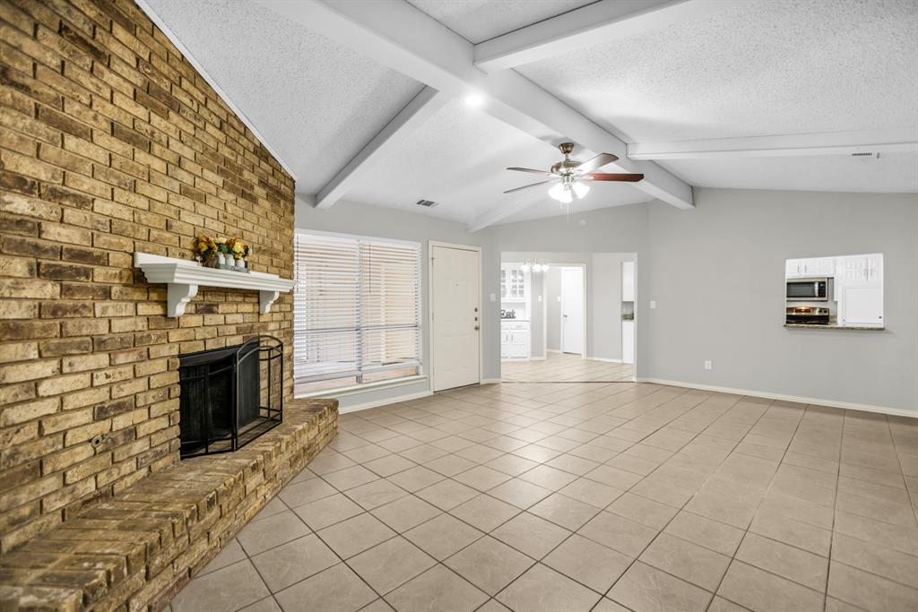 5902 Fawn Valley Lane Rowlett, TX 75089 - Photo 7 of 27 an empty room with windows and fireplace