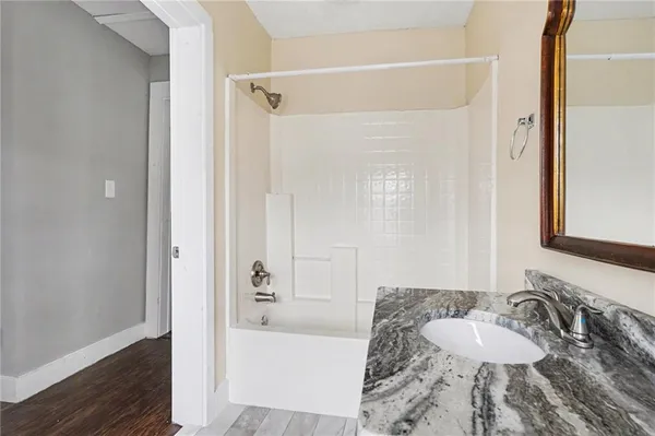 a bathroom with a granite countertop sink and a mirror
