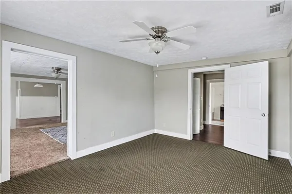 a view of a livingroom with a ceiling fan & entryway