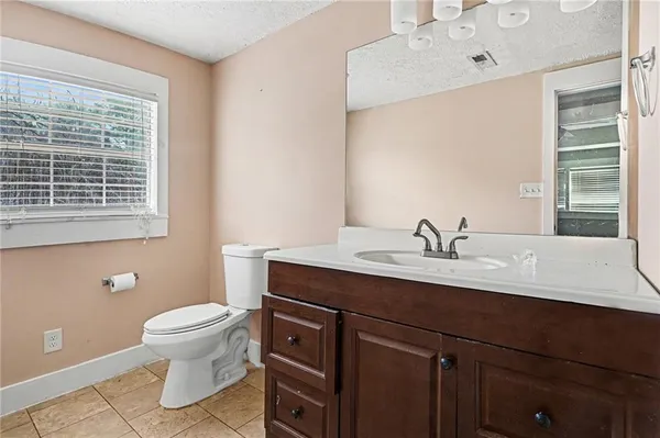 a bathroom with a granite countertop sink toilet and mirror