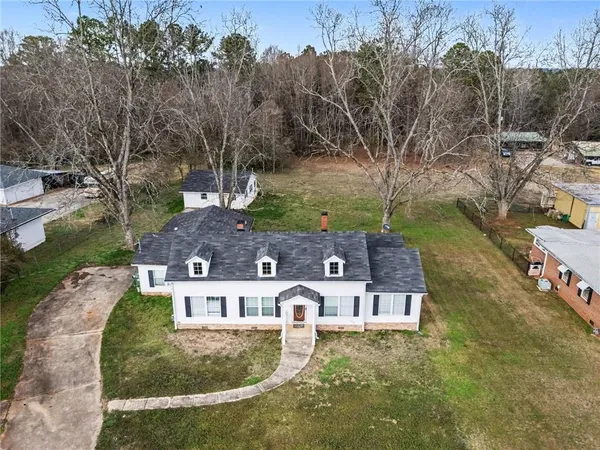an aerial view of residential houses with outdoor space and trees