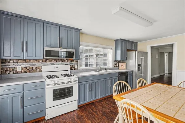 a kitchen with stainless steel appliances a stove a sink cabinets and a refrigerator