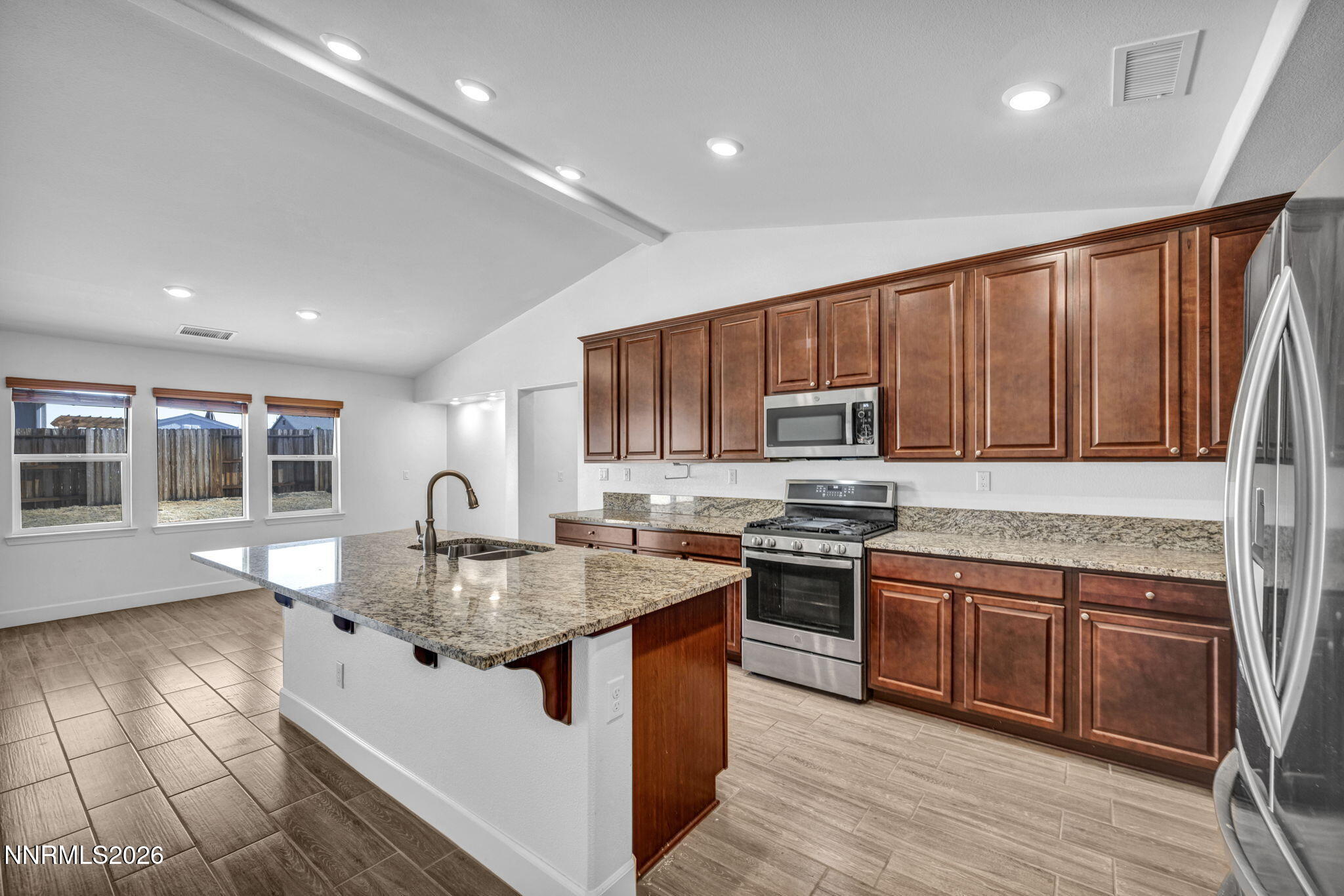 7181 Saddlehorn Road Carson City, NV 89701 - Photo 19 of 62 a kitchen with stainless steel appliances granite countertop wooden cabinets a sink and a stove