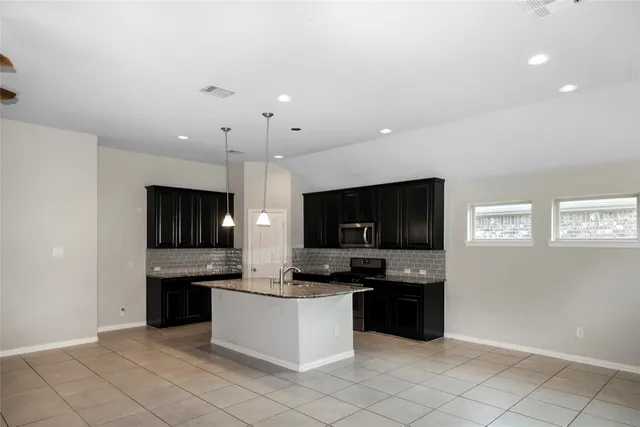 a kitchen with stainless steel appliances a stove top oven and cabinets