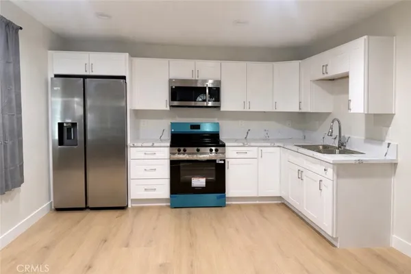 a kitchen with white cabinets and stainless steel appliances