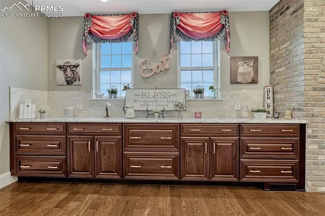 a bathroom with a granite countertop double vanity sink and a mirror