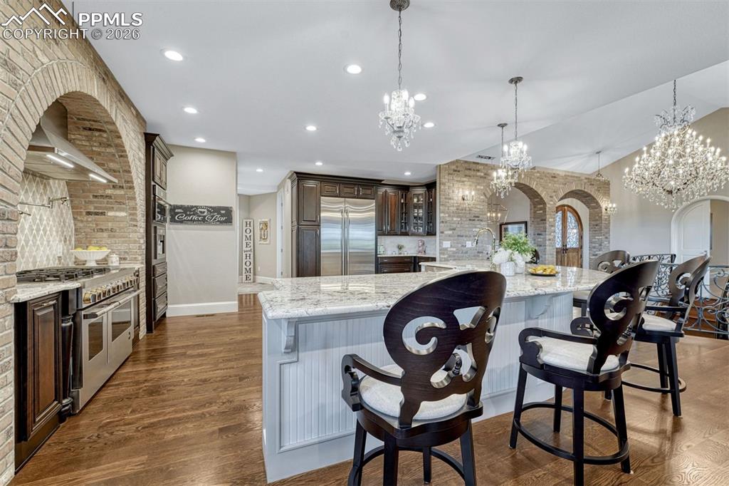 25995 Cave Spg Trail Elbert, CO 80106 - Photo 19 of 50 a kitchen with stainless steel appliances granite countertop a stove a sink a refrigerator and chairs
