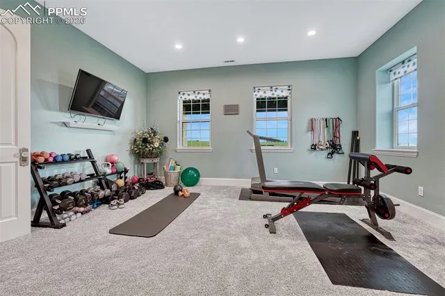a room with gym equipment and a flat screen tv
