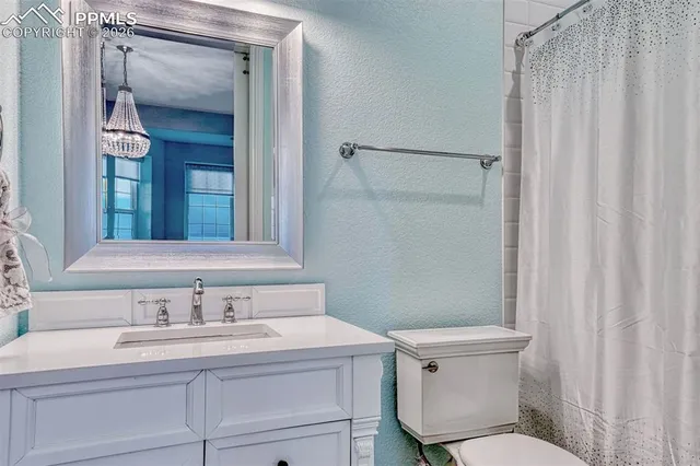 a bathroom with a granite countertop sink toilet and a mirror