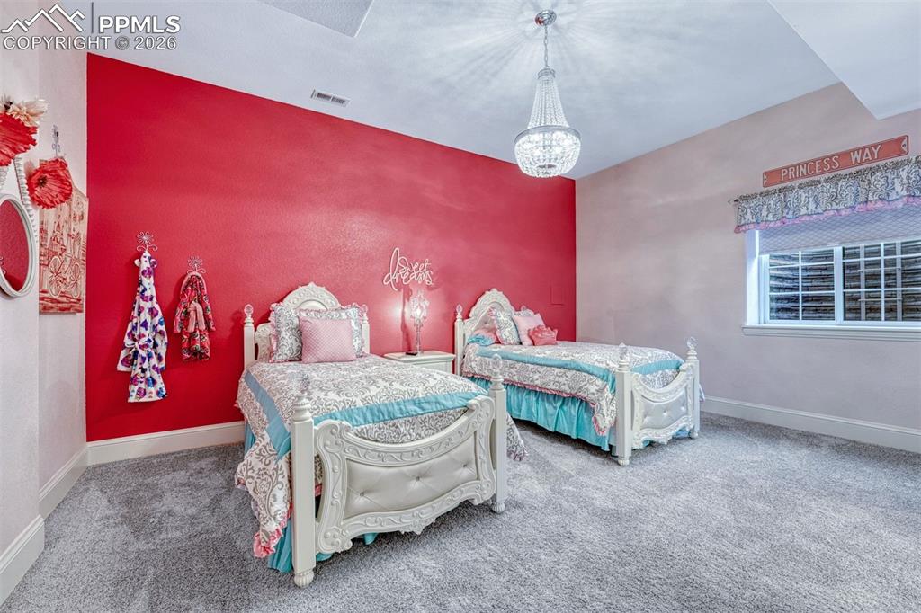 25995 Cave Spg Trail Elbert, CO 80106 - Photo 45 of 50 a bedroom with a bed and a chandelier