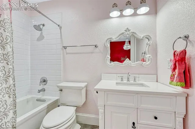 a bathroom with a toilet sink vanity tub and mirror