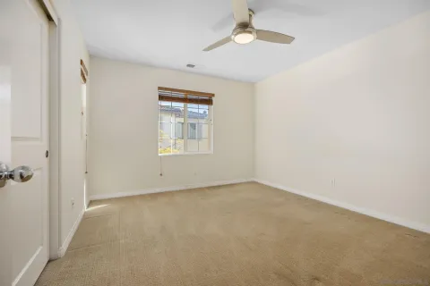 an empty room with a window and a fan