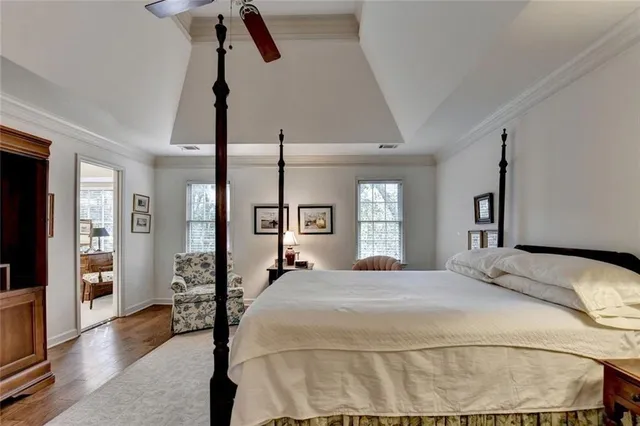 a bedroom with a large bed and a chandelier