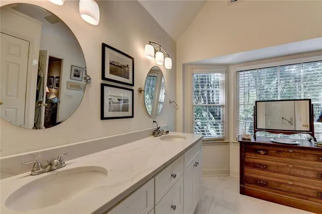 a bathroom with 2 sink tub and a mirror