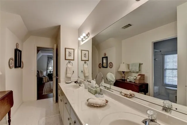 a spacious bathroom with a granite countertop sink and a mirror