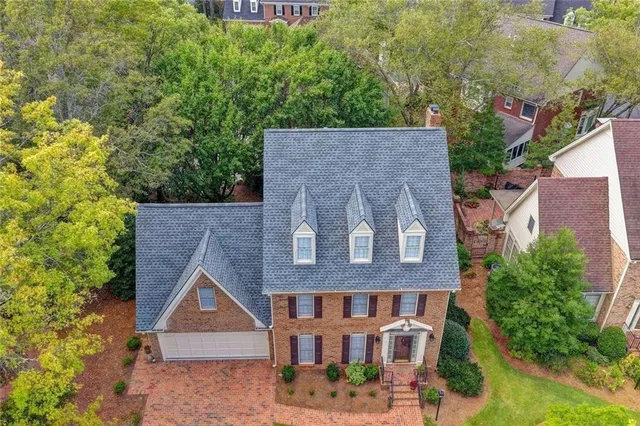 an aerial view of a house with outdoor space and tennis court
