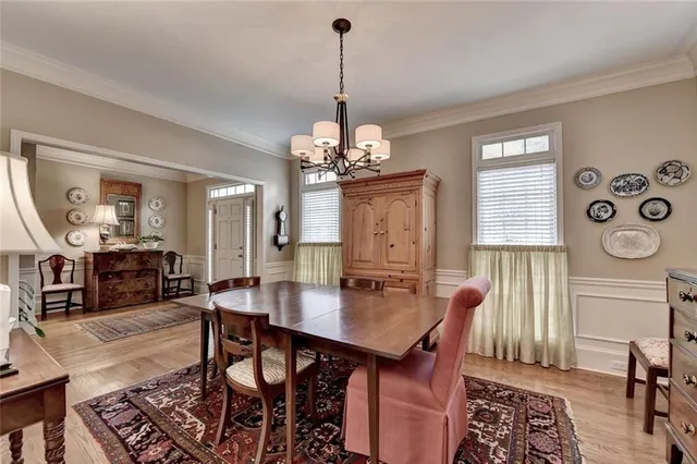 a dining room with furniture a chandelier and wooden floor
