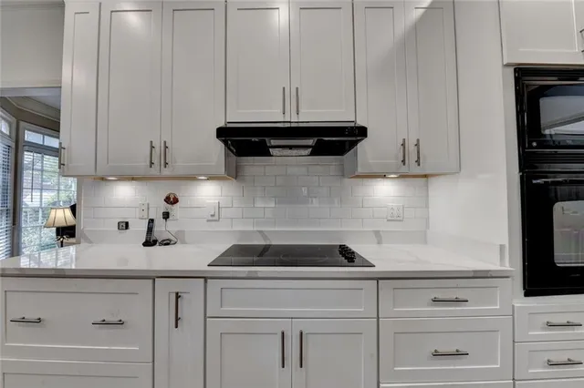 a kitchen with white cabinets and appliances