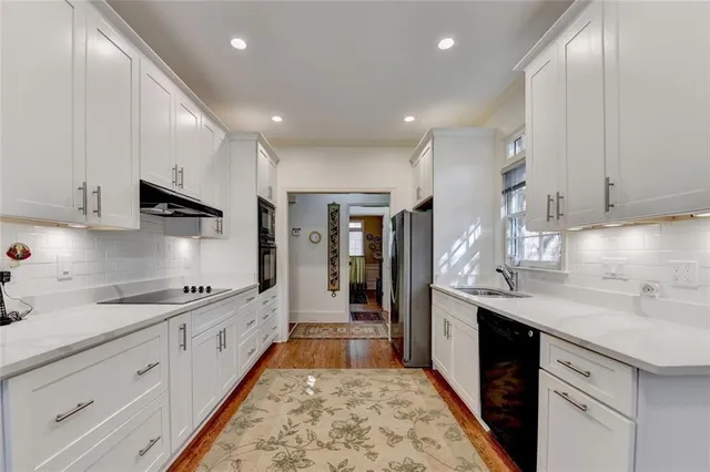 a large kitchen with stainless steel appliances granite countertop a sink and cabinets