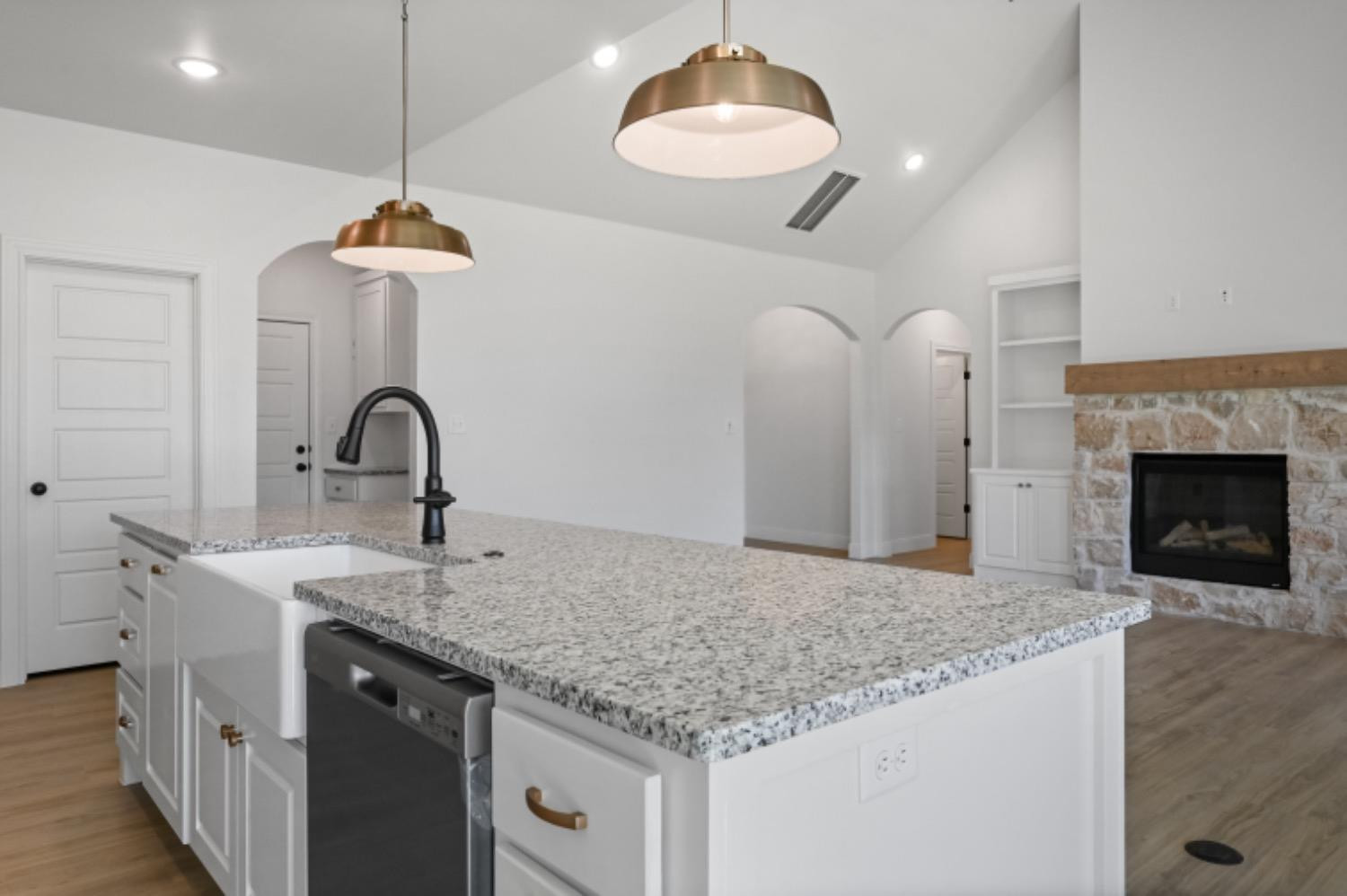 5607 119th Street Lubbock, TX 79424 - Photo 11 of 33 a kitchen with stainless steel appliances granite countertop a sink a refrigerator and a fireplace