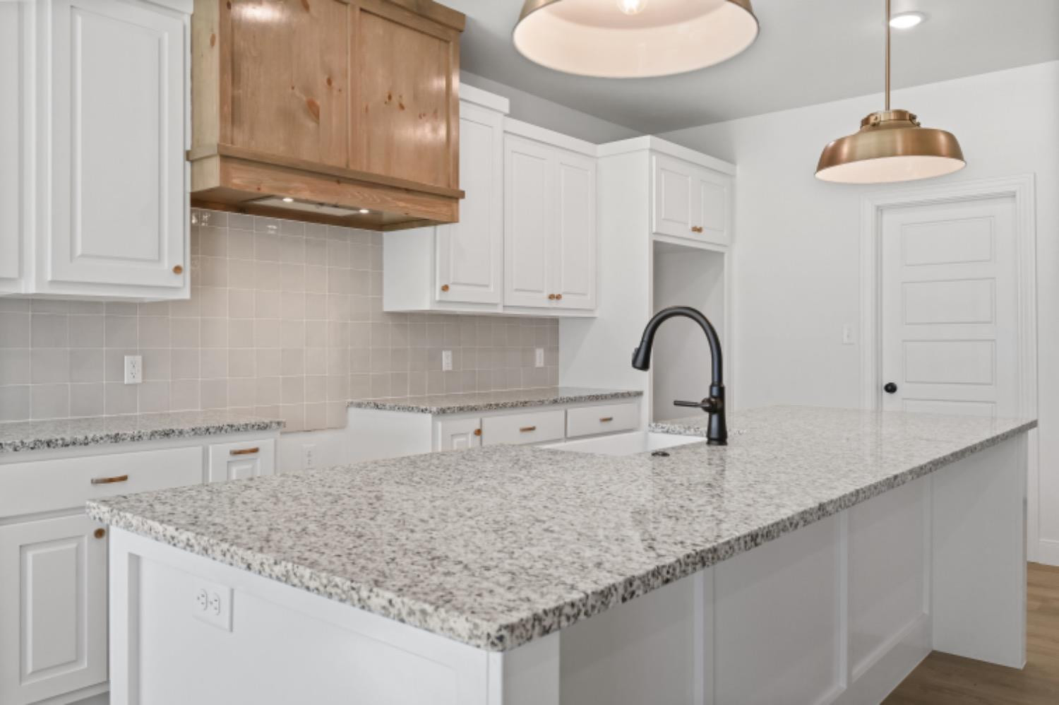 5607 119th Street Lubbock, TX 79424 - Photo 12 of 33 a kitchen with granite countertop white cabinets and a sink