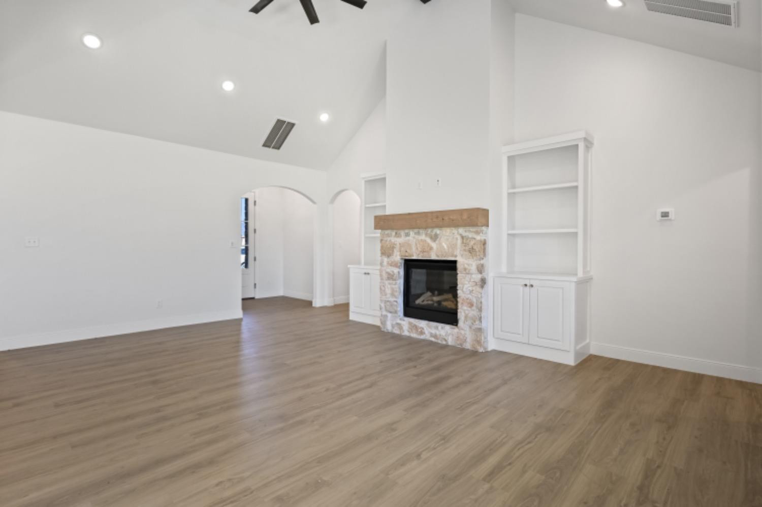 5607 119th Street Lubbock, TX 79424 - Photo 6 of 33 an empty room with wooden floor and fireplace