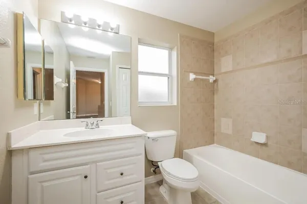 a bathroom with a sink a toilet a mirror and shower