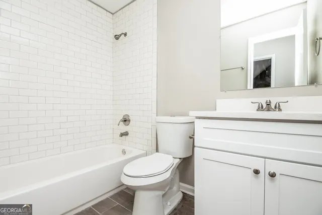 a bathroom with a toilet a sink a mirror and bathtub