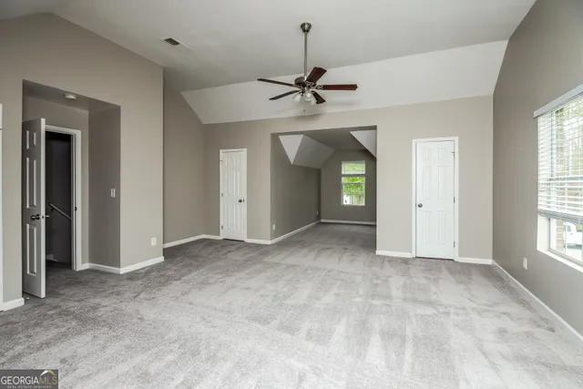 an empty room with fan and windows