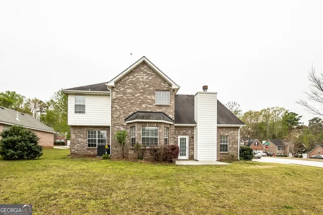 a view of a big house with a big yard and large trees