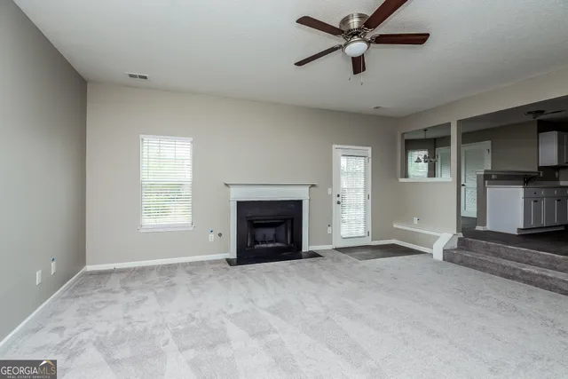 a view of a livingroom with a fireplace and window