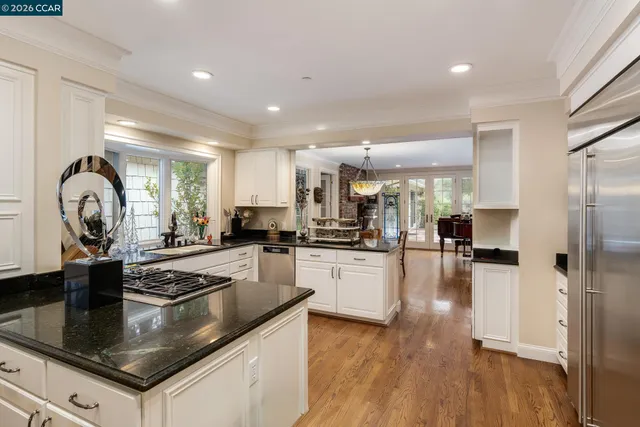 a kitchen with stainless steel appliances granite countertop a sink refrigerator and cabinets