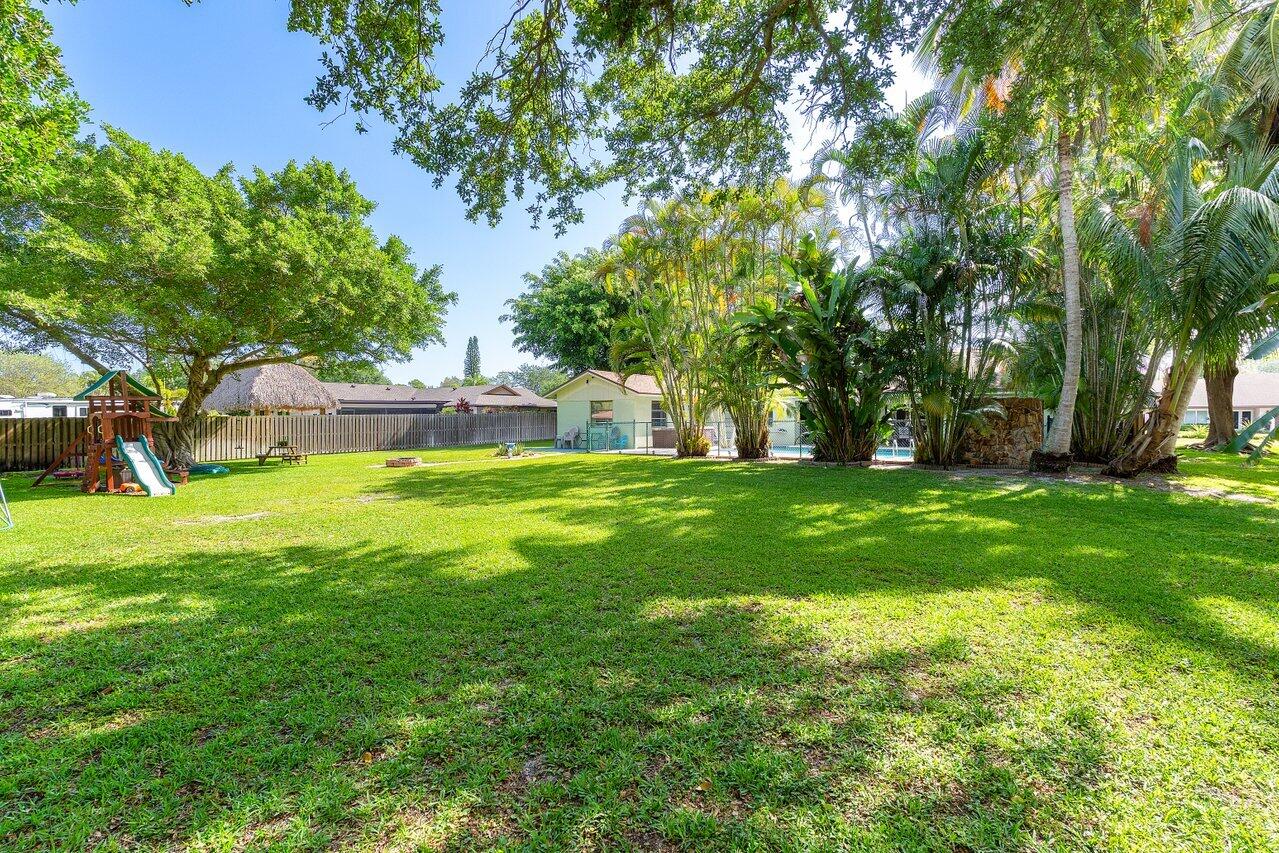 267 Old Country Road South Wellington, FL 33414 - Photo 20 of 22 a view of green field with trees in the background