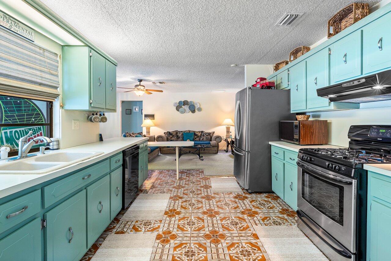 267 Old Country Road South Wellington, FL 33414 - Photo 7 of 22 a kitchen with a sink stove and cabinets